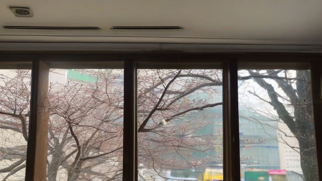 한국인 직장인이 저녁 시간에 집에서 노트북으로 부업하며 미소 짓는 모습